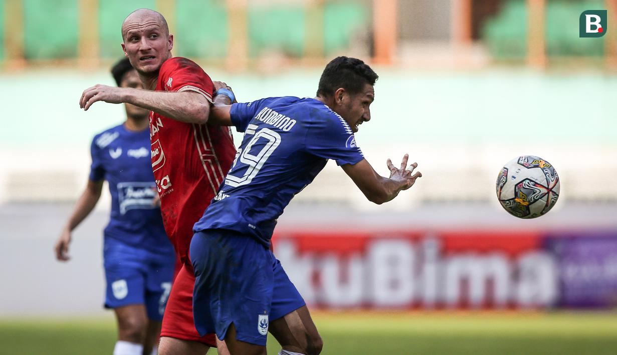<p>Pemain Persija Jakarta, Michael Krmencik (kiri) berebut bola dengan pemain PSIS Semarang, Delfin Rumbino pada laga lanjutan BRI Liga 1 2022/2023 di Stadion Wibawa Mukti, Cikarang, Kamis (16/03/2023). (Bola.com/Bagaskara Lazuardi)</p>