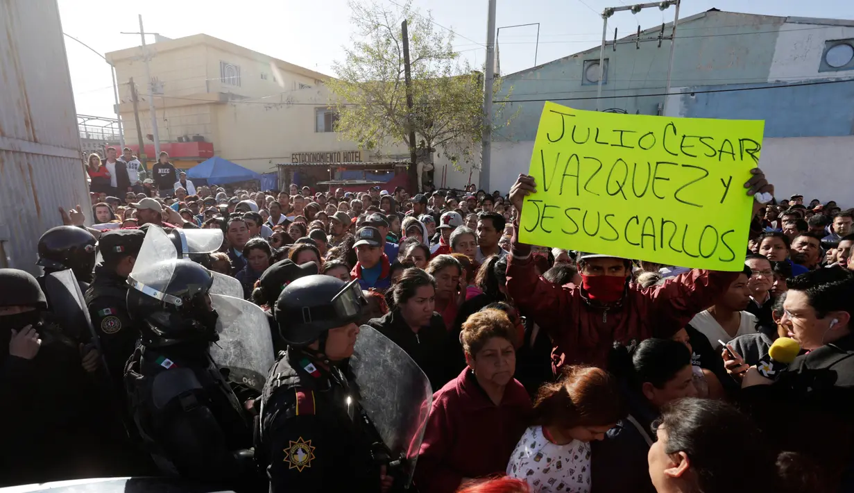 Seorang pria memegang kertas bertuliskan nama-nama tahanan saat berdiri di luar penjara Topo Chico, Monterrey, Meksiko, Kamis (11/2). 52 orang tewas dan 12 terluka dalam kerusuhan di penjara yang terjadi menjelang fajar itu. (REUTERS/Daniel Becerril)
