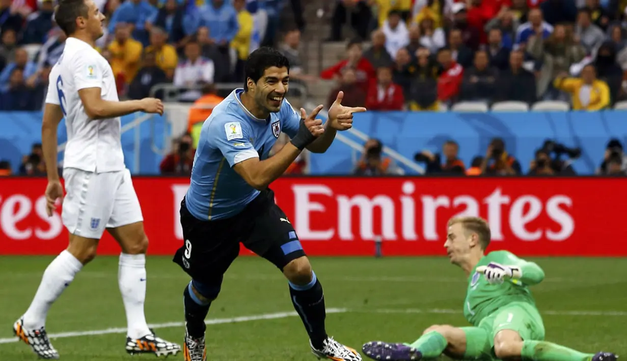 Penyerang Uruguay, Luis Suarez (tengah) merayakan gol pertamanya ke gawang Inggris saat berlaga di fase penyisihan Piala Dunia 2014 Grup D di Stadion Corinthians, Sao Paulo, Brasil, (20/6/2014). (REUTERS/Damir Sagolj)