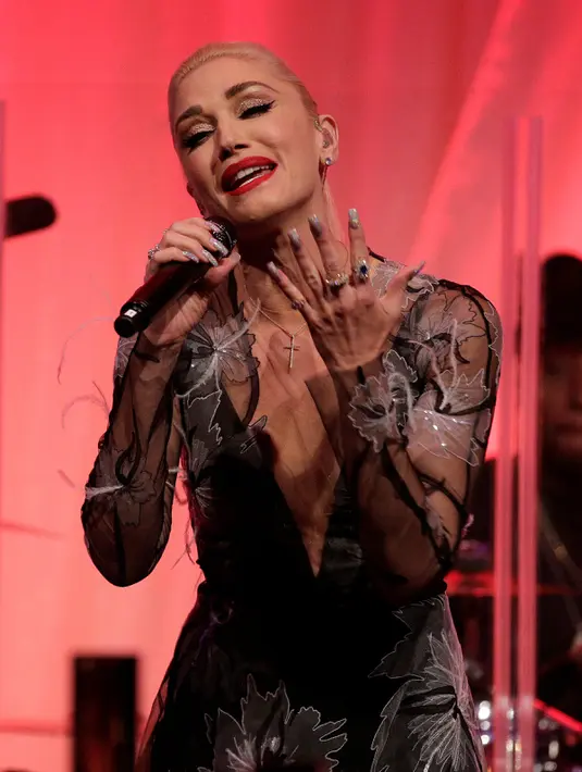 Ekspresi Gwen Stefani saat mengisi acara makan malam menyambut kedatangan perdana menteri Italia Matteo Renzi di Gedung Putih, Washington, AS (18/10). Gwen tampak anggun menggunakan gaun hitam bermotif daun. (Reuters/Joshua Robert)