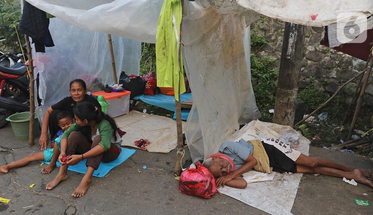 Warga mengungsi di tenda yang didirikannya di jalan Desa Sumber Urip Pebayuran, Senin (22/2/2021). Sudah tiga hari warga bertahan di tenda pengungsian dikarenakan banjir luapan sungai Citarum yang merendam permukiman warga kampung Babakan Banten Pebayuran. (Liputan6.com/Herman Zakharia)