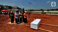 Keluarga korban mensalatkan jenazah untuk dimakamkan di lahan baru tempat pemakaman umum (TPU) khusus COVID-19, Jombang, Tangerang Selatan, Banten,Senin (26/7/2021). Pemkot Tangerang Selatan membuka lahan baru TPU khusus COVID-19 yang dapat menampung 800 makam. (merdeka.com/Arie Basuki)