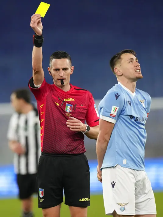 Wasit Daniele Minelli menunjukkan kartu kuning kepada pemain Lazio Patric saat melawan Udinese pada pertandingan sepak bola Coppa Italia di Olympic Stadium, Roma, Italia, 18 Januari 2021. Lazio menang dengan skor 1-0. (AP Photo/Andrew Medichini)