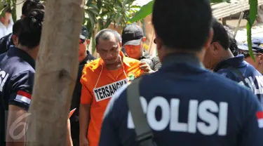 Tersangka Agus Dermawan saat melakukan reka ulang pembunuhan bocah di dalam kardus, Jakarta, Selasa (20/10/2015). Proses rekonstruksi pembunuhan bocah dalam kardus  menjadi tontonan warga sekitar. (Liputan6.com/Gempur M Surya)