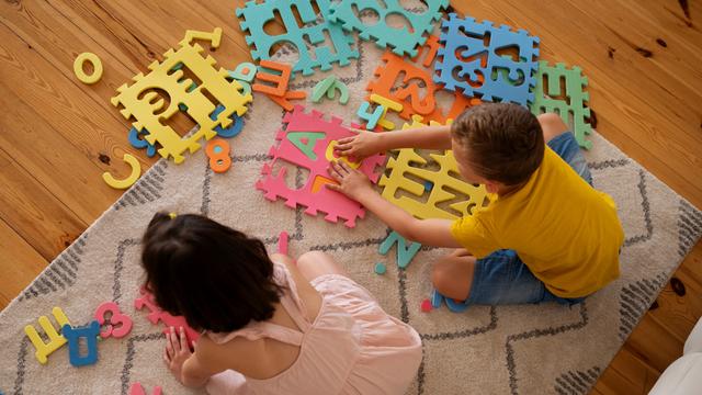 Dua Anak Sedang Bermain Puzzle Huruf