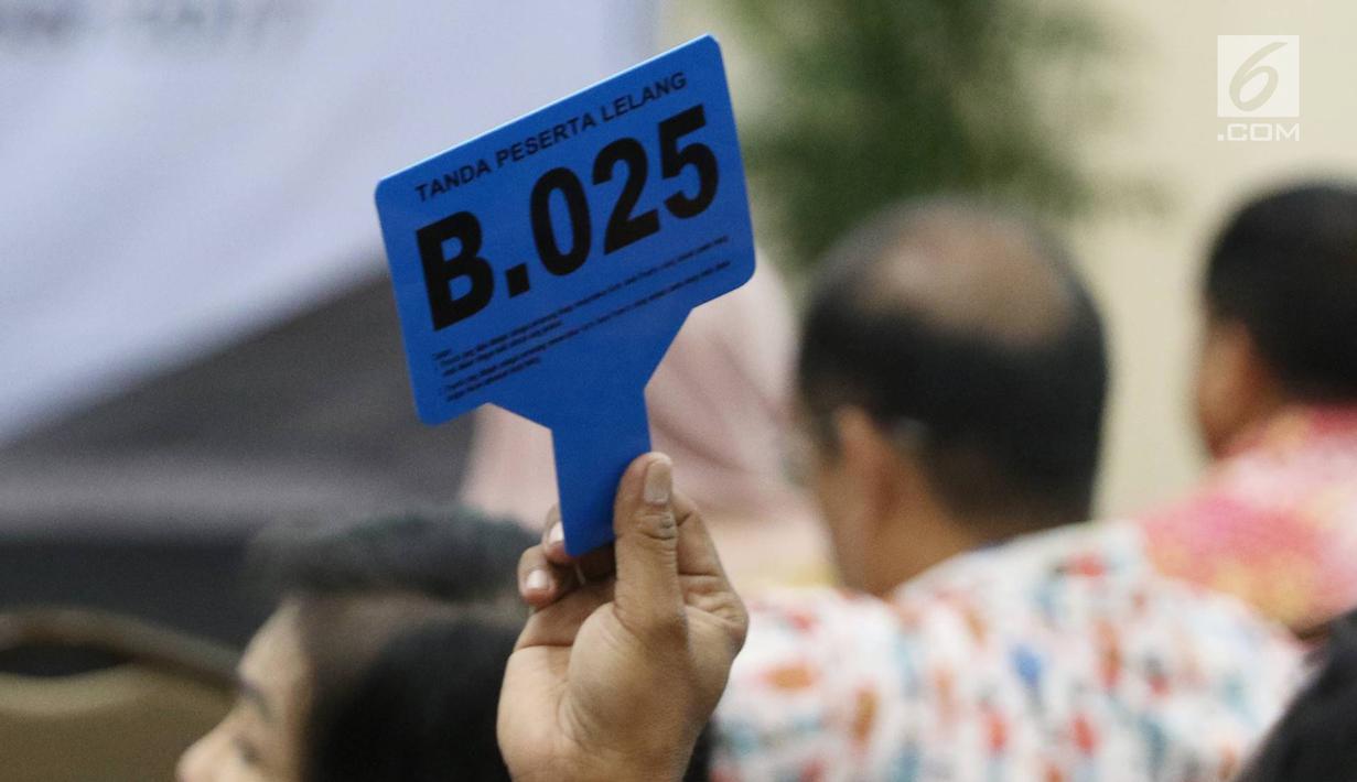 Peserta menunjukkan nomor tanda peserta lelang di Gedung Komisi Pemberantasan Korupsi (KPK), Jumat (24/11). Melalui Kantor Pelayanan Kekayaan Negara dan Lelang (KPKNL) Jakarta III, KPK melelang sejumlah jenis barang sitaan.(Liputan6.com/Immanuel Antonius)