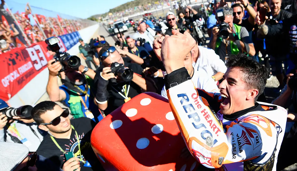 Pembalap Spanyol Repsol Honda, Marc Marquez meluapkan kegembiraannya setelah memenangkan balapan seri ke 18 MotoGP Grand Prix Valencia di Sirkuit Ricardo Tormo, Valencia (12/11). Marquez berhasil mengumpulkan total 298 poin. (AFP PHOTO / Jose Jordan)