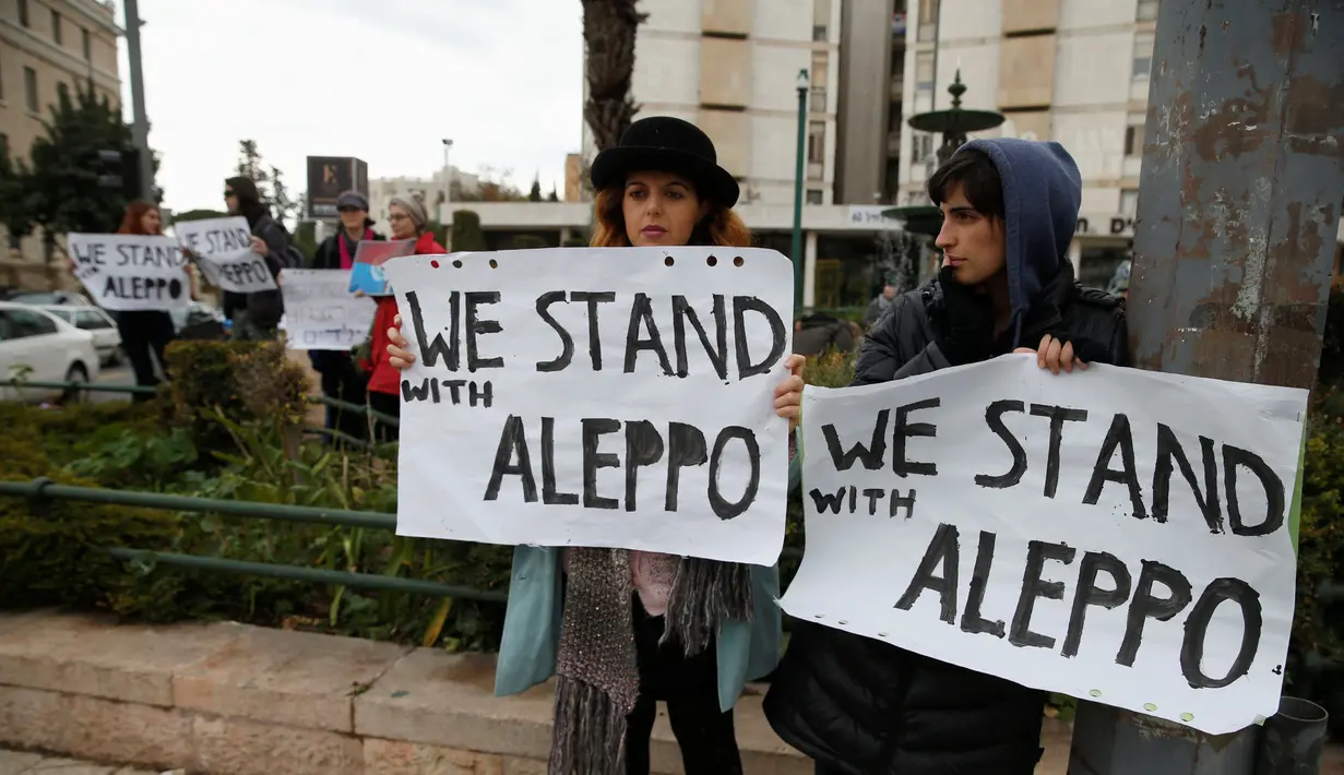 Dua warga Israel berunjuk rasa di depan kediaman Perdana Menteri Israel, Benjamin Netanyahu di Yerusalem, Jumat (16/12). Mereka mengaku prihatin dengan warga Aleppo di Suriah. (REUTERS / Baz Ratner)