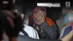Panitera Pengganti PN Tangerang, Tuti Atika menutup wajah usai diperiksa di gedung KPK, Jakarta, Selasa (13/3). Tuti Atika berstatus tersangka bersama Hakim PN Tangerang Wahyu Widya Nurfitri dan dua pengacara. (Liputan6.com/Herman Zakharia)