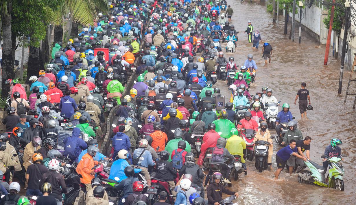 Genangan air yang merendam jalur dari arah Grogol menuju Cengkareng maupun arah sebaliknya ini sudah terjadi sejak Kamis 22 Januari 2026. Tampak dalam foto, antrean pengendara motor yang mencoba menerobos banjir di Jalan Daan Mogot, Jakarta, Jumat (23/1/02026). (merdeka.com/ Arie Basuki)