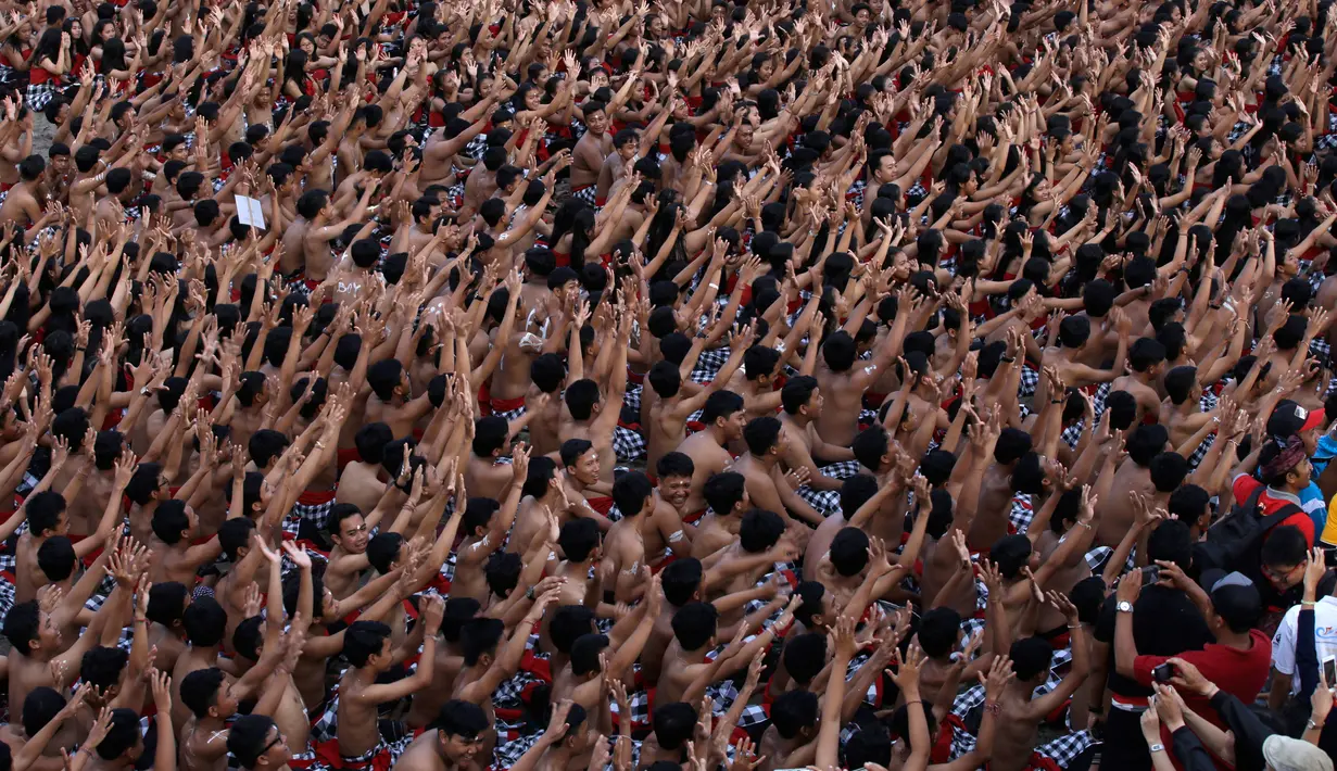 Ribuan pelajar menampilkan Tari Kecak Kolosal saat upaya pemecahan rekor Museum Rekor Dunia Indonesia (MURI) di Pantai Berawa, Badung, Bali, Minggu (25/2). Mereka mengenakan kain kemben bercorak kotak-kotak hitam putih. (AP/Firdia Lisnawati)