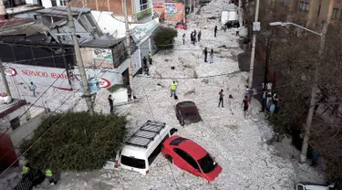 Sejumlah kendaraan ter tertimbun salju di jalanan di wilayah timur Guadalajara, negara bagian Jalisco, Meksiko (30/6/2019). Enam daerah suburban di Kota Guadalajara, Meksiko, diselimuti salju tebal setelah diterjang hujan es. (AFP Photo/Ulises Ruiz)