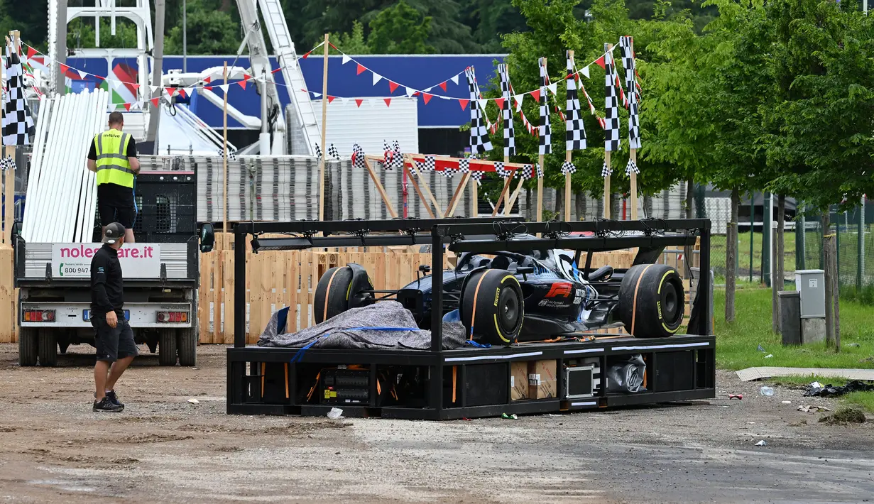Sebuah mobil uji coba F1 kembali diangkat menuju kendaraan angkut di sirkuit Autodromo Enzo e Dino Ferrari, Kamis (18/5/2023), setelah banjir bandang melanda kawasan tersebut sehari sebelumnya. (AFP/Andreas Solaro)