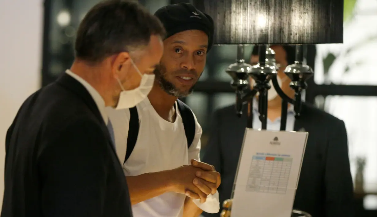 Mantan pemain timnas Brasil, Ronaldinho tiba di sebuah hotel untuk menjalani tahanan rumah di Asuncion, Paraguay, Selasa (7/4/2020). Ronaldinho kini berstatus tahanan kota setelah dibebaskan dari penjara dengan dengan membayar uang jaminan sebesar sekitar Rp 25 miliar. (AP/Jorge Saenz)