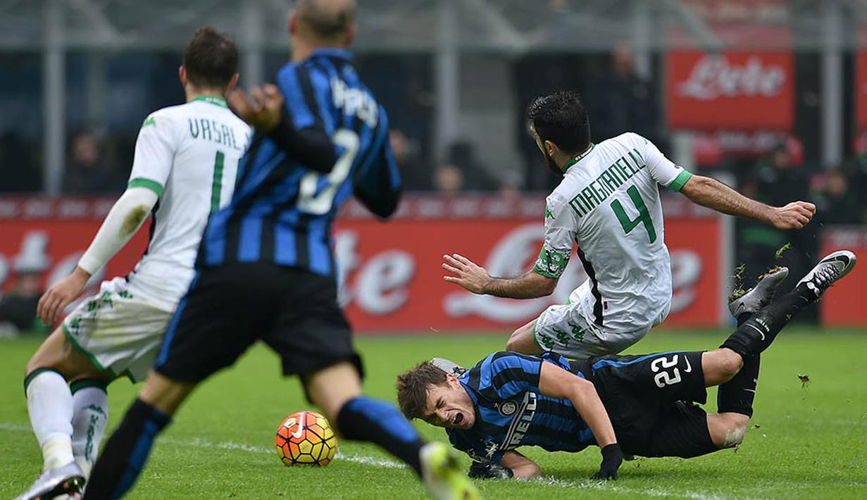 Penyerang Inter Milan, Adam Ljajic, terjatuh saat berebut bola dengan gelandang Sassuolo, Francesco Magnanelli, pada laga Serie A. Sementara bagi Sassuolo ini merupakan kemenangan kedelapan mereka. (AFP/Alberto Pizzoli)