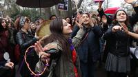 Seorang wanita bernyanyi dan menari saat berkumpul untuk memperingati Women's Day atau Hari Perempuan Internasional di Ankara, Turki, Kamis (8/3). (ADEM ALTAN/AFP)