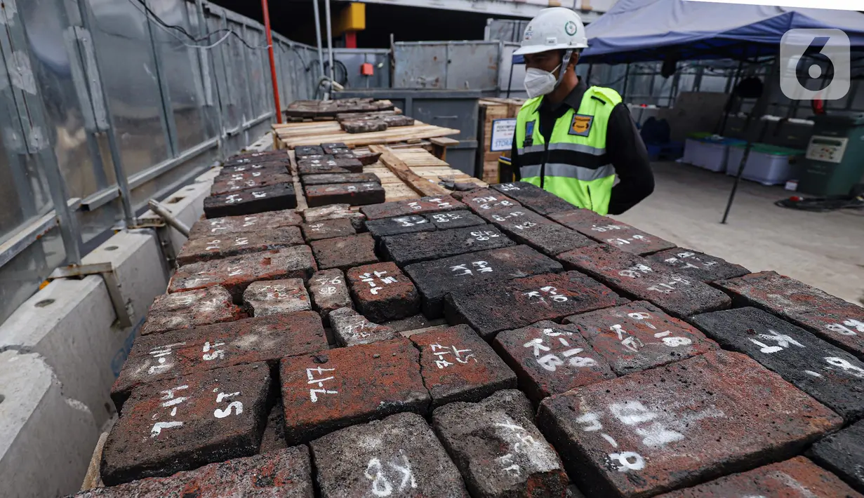 Pekerja melihat artefak yang ditemukan di sepanjang proyek MRT CP203 Glodok-Kota, Jakarta, Selasa (20/9/2022). Artefak mulai dari pecahan keramik, botol, dan bata zaman kolonial ditemukan sepanjang proyek MRT CP203 Bundaran HI-Kota, Jakarta Barat. (Liputan6.com/Faizal Fanani)