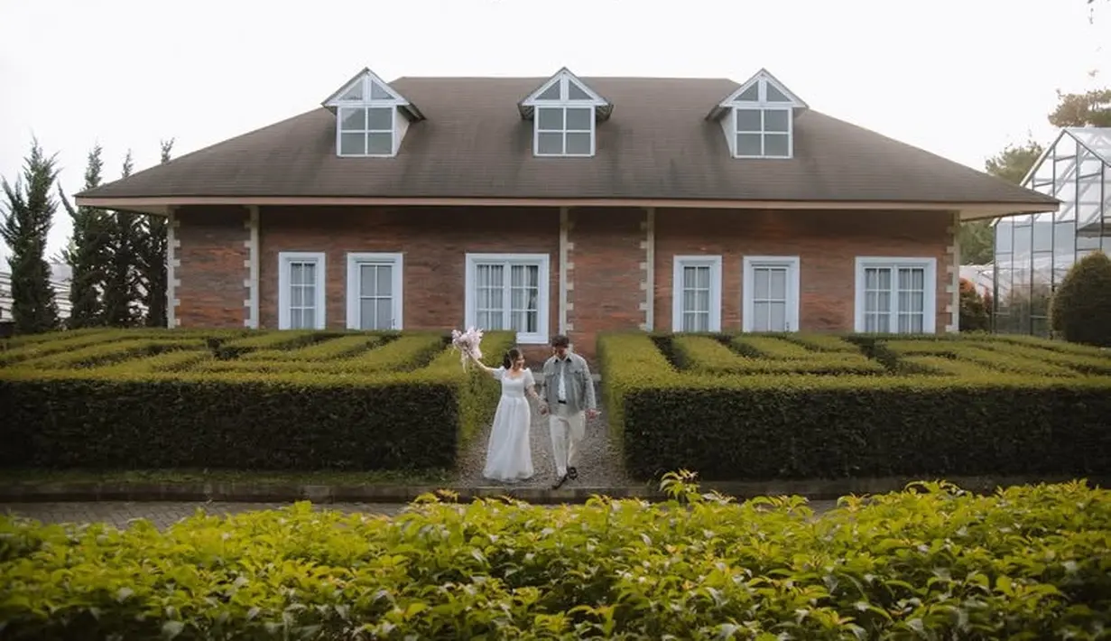 Tampak Indah pun mengenakan long dress putih seperti gaun putih. Frans mengenakan kemeja abu-abu dan celana putihnya.  [@fransfaisal_]