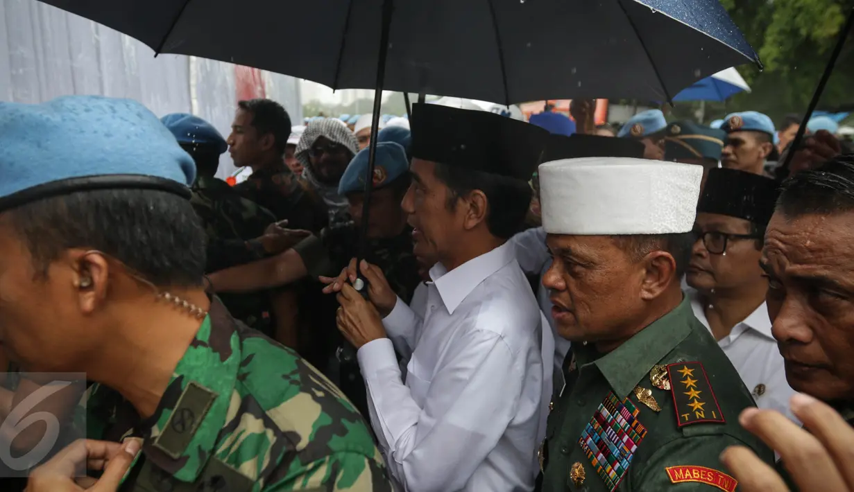 Presiden Joko Widodo didampingi Panglima Jendral TNI Gatot Nurmanyto berjalan untuk melaksanakan salat jumat bersama dalam Aksi Bela Islam Jilid 3 di Monumen Nasional, Jakarta, Jumat (2/12). (Liputan6.com/Faizal Fanani)