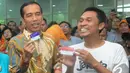 Presiden Jokowi bersama seorang warga menunjukkan Kartu Indonesia Sehat di Kantor Pos Pasar Baru, Jakarta, Senin (3/11/2014). (Liputan6.com/Herman Zakharia)