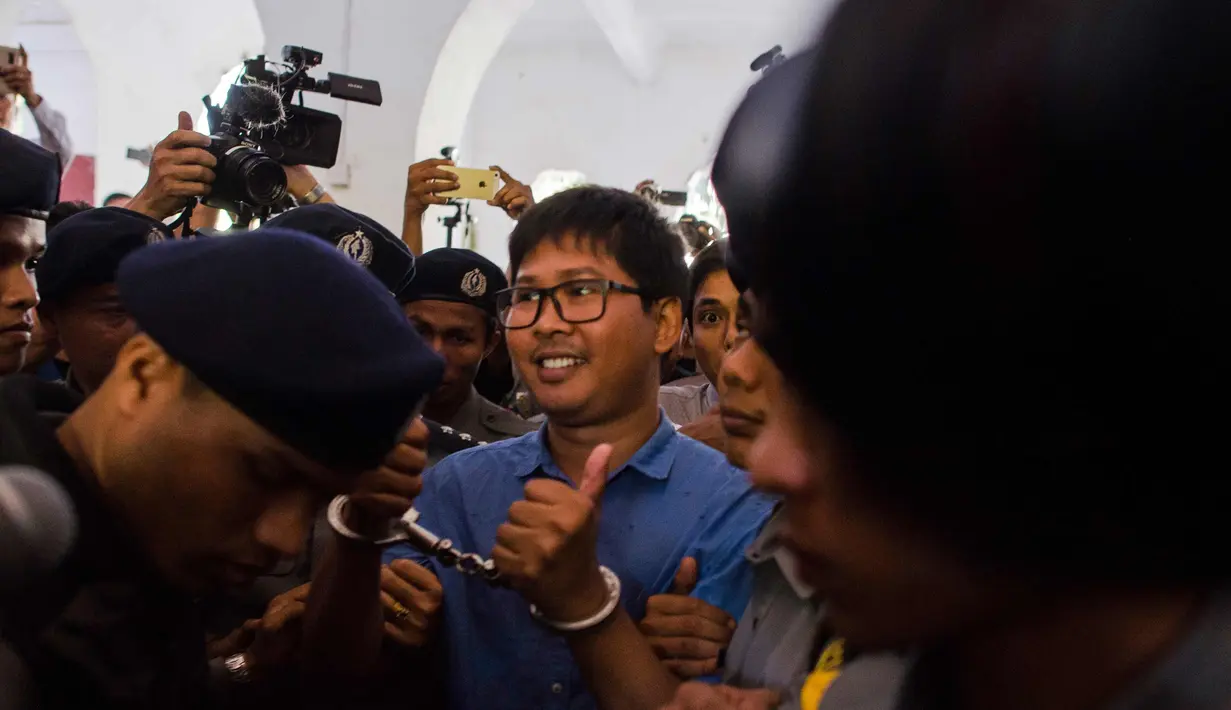 Wartawan Reuters Wa Lone dengan tangan di borgol tiba untuk menjalani sidang di Yangon (10/1). Menurut hakim, Wa Lone dan Kyaw Soe Oo akan dihukum selama 14 tahun jika terbukti bersalah. (AFP Photo/Ye Aung Thu)