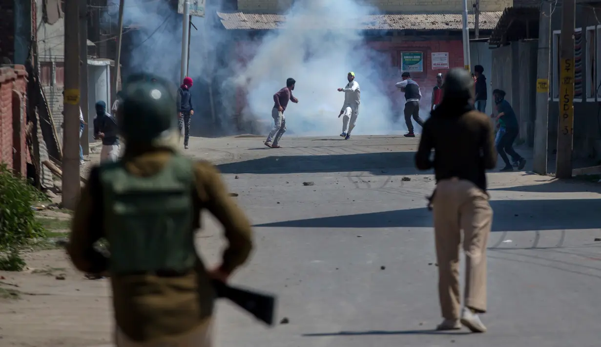 Pemuda Kashmir melempari batu ke arah tentara India saat merekam yang memprotes pembunuhan kelompok militan di Srinagar (4/1). (AP Photo / Dar Yasin)