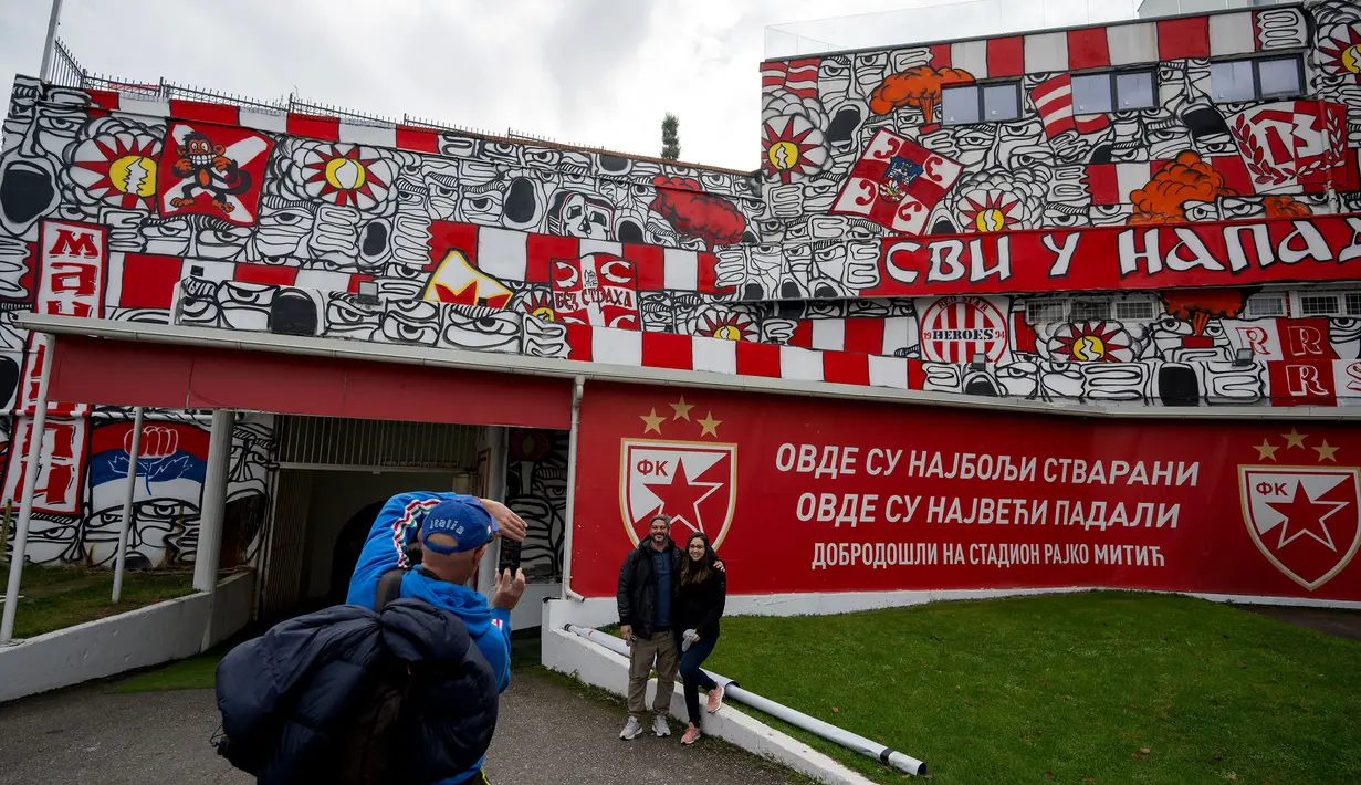 Sejumlah pengunjung berfoto dengan mural yang terletak di pintu masuk terowongan terkenal Stadion Rajko Mitic, Beograd, Serbia dua hari sebelum pertandingan sepak bola Grup G Liga Champions UEFA antara Crvena Zvezda (Red Star Belgrade) dan Manchester City pada 11 Desember 2023 waktu setempat. (AFP/Andrej Isakovic)