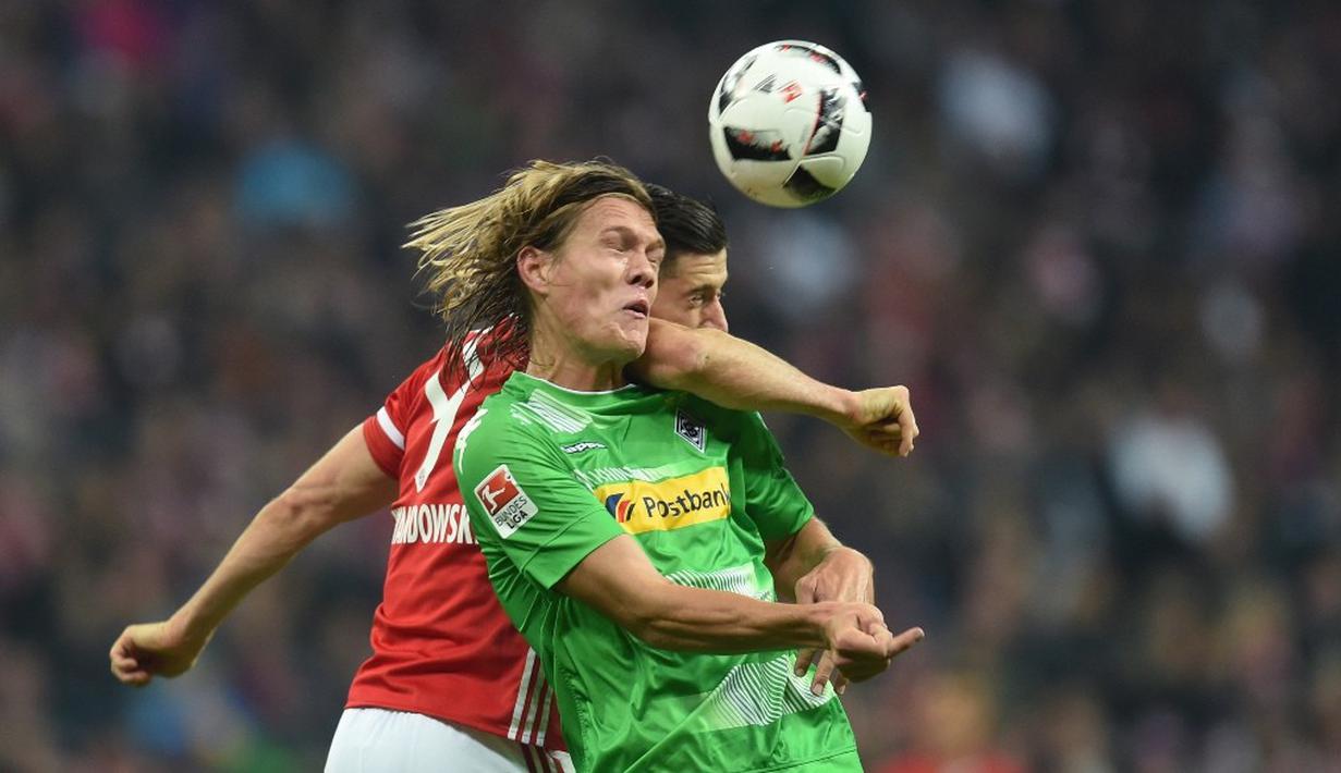 Striker Bayern Munchen, Robert Lewandowski, berduel dengan pemain Borussia Monchengladbach, Jannik Vestergaard, dalam laga pekan ke-8 Bundesliga 2016-2017, Sabtu (23/10/2016). (AFP/Christof Stache)