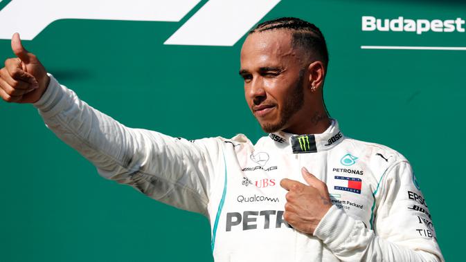 Pembalap Mercedes, Lewis Hamilton berselebrasi setelah berhasil menjuarai GP Hungaria di Sirkuit Hungaroring, Mogyorod, (29/7). Kemenangan Hamilotn menjadi yang kelima sepanjang musim ini. (AP Photo/Laszlo Balogh)