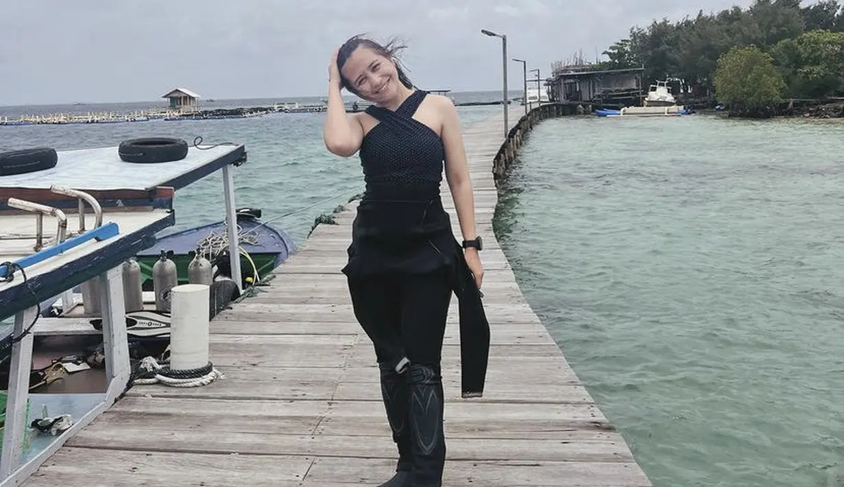 Di bawah baju divingnya, Prilly mengenakan inner halterneck hitam. Ia pun terlihat mengenakan jam tangan hitamnya. (@prillylatuconsina96)