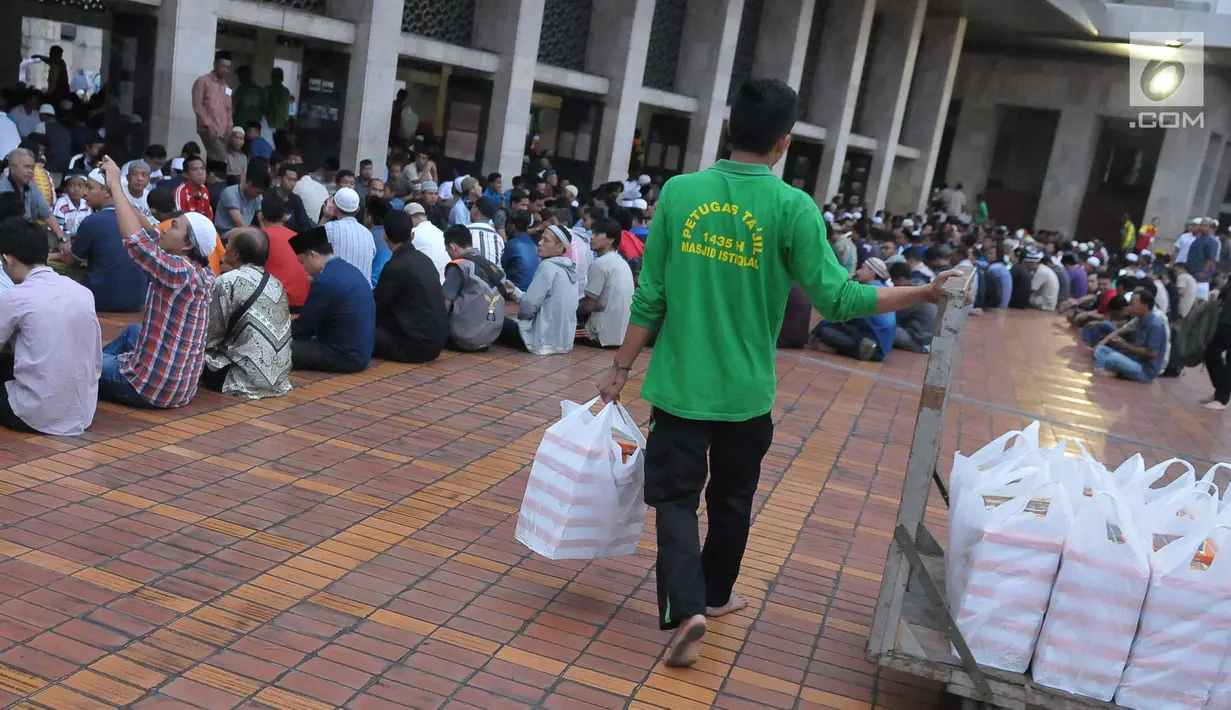 Petugas membagikan takjil jelang berbuka puasa pada hari kedua bulan Ramadan di Masjid Istiqlal, Jakarta, Minggu (28/5). Panitia masjid juga menyiapkan 3000 kotak makanan pada hari Senin - Kamis.(Liputan6.com/Helmi Afandi) 