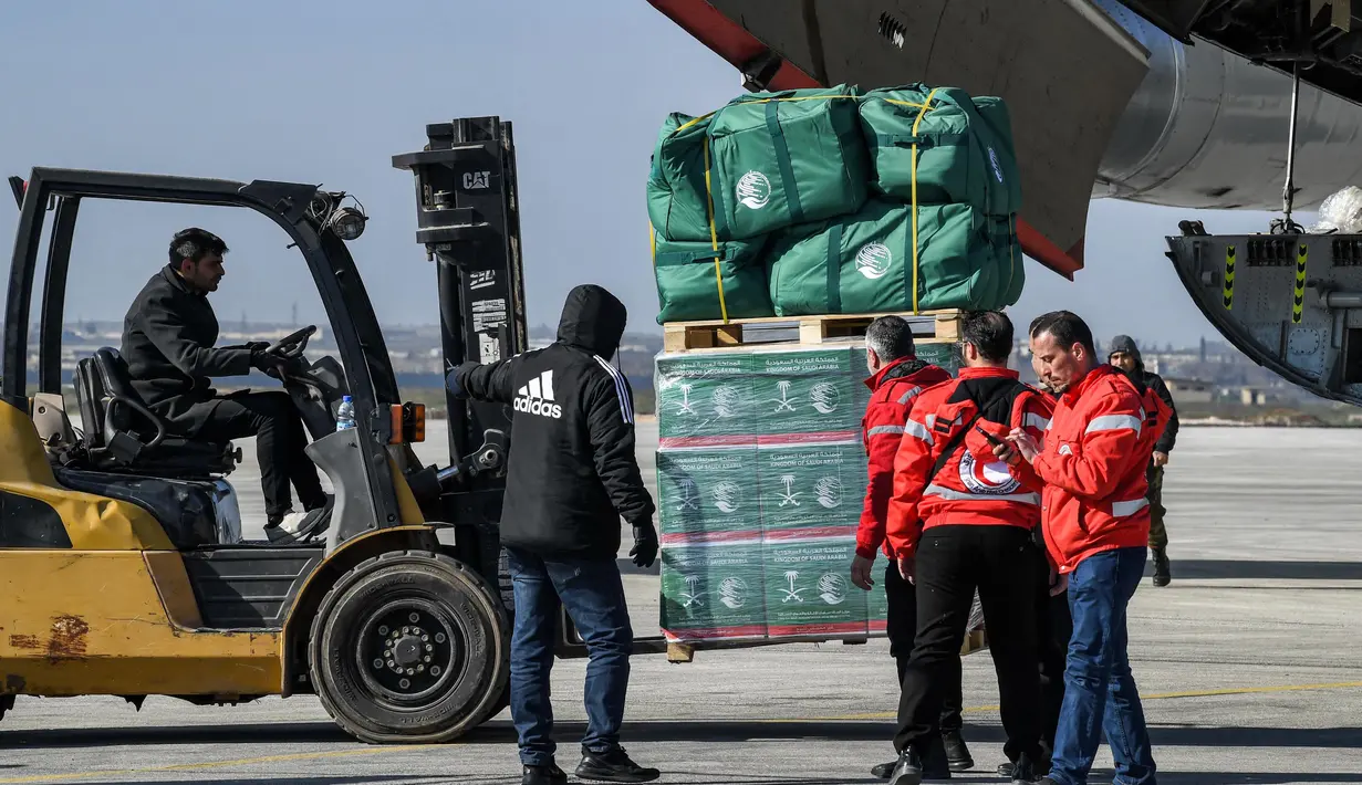 Personil gabungan setempat menurunkan paket bantuan kemanusiaan yang disediakan oleh Arab Saudi untuk para korban gempa bumi Turki dan Suriah diturunkan dari pesawat angkut Ilyushin Il-76TD di Bandara Internasional Aleppo, Suriah Utara, Selasa (14/2/2023). Jumlah korban gempa Turki dan Suriah terus bertambah. Banyak warga yang tinggal di zona bencana tidur di mobil mereka atau di jalan di bawah selimut dalam cuaca dingin yang membekukan. (AFP)