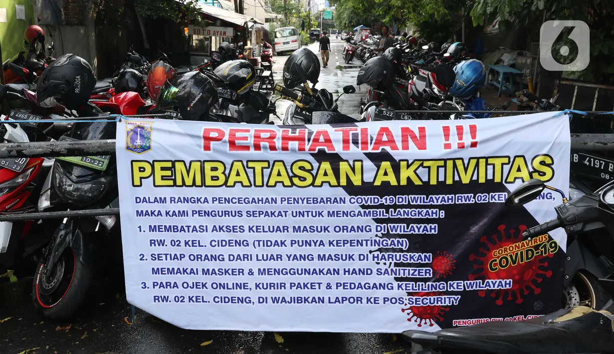 Spanduk tentang pembatasan aktivitas terpampang di pintu masuk perumahan di kawasan Cideng, Jakarta, Kamis (2/4/2020). Pemerintah menetapkan Pembatasan Sosial Berskala Besar dengan membatasi kegiatan tertentu penduduk di wilayah yang diduga terinfeksi COVID-19. (Liputan6.com/Helmi Fithriansyah)
