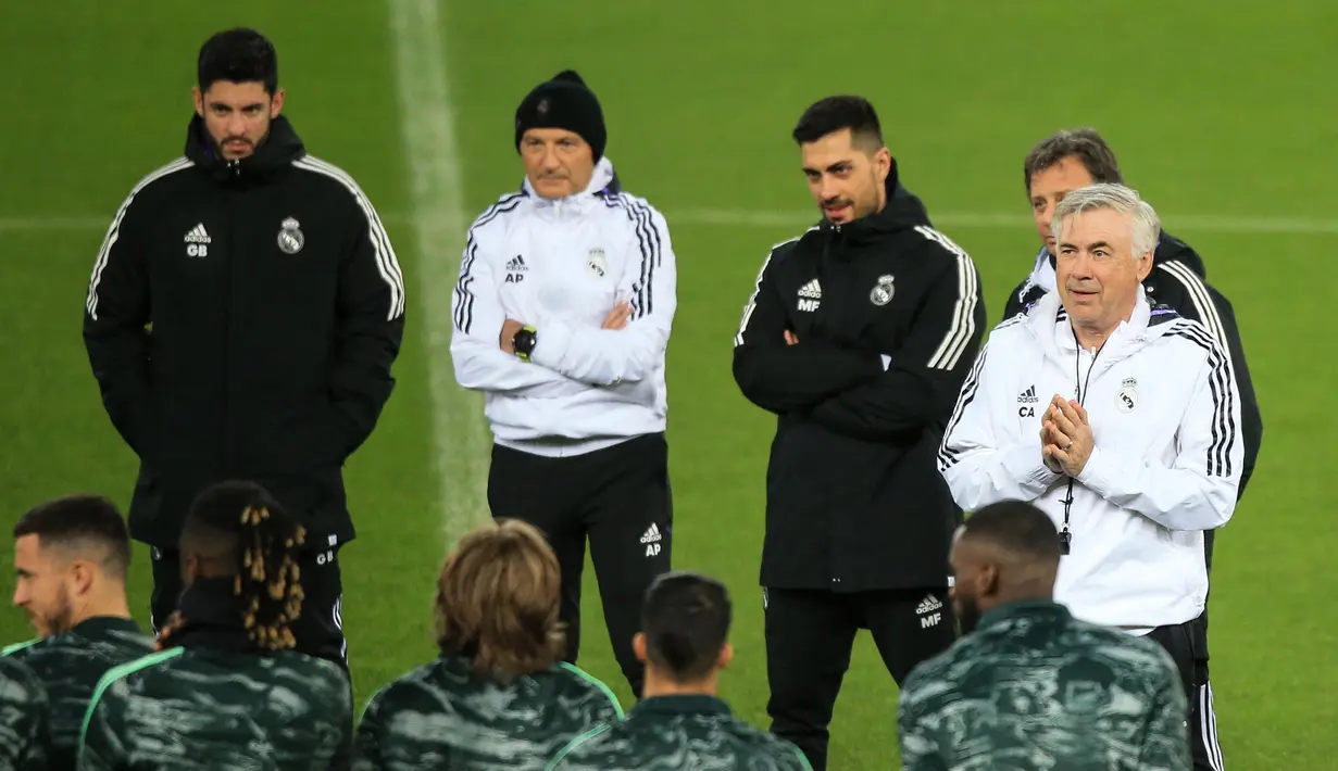 <p>Pelatih Real Madrid, Carlo Ancelotti (kanan) berbicara kepada para pemainnya selama sesi latihan di Stadion Anfield di Liverpool, barat laut Inggris pada 20 Februari 2023. Madrid akan bertanding melawan Liverpool pada pertandingan leg pertama babak 16 besar Liga Champions. (AFP/Lindsey Parnaby)</p>