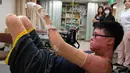 Seorang pria bernama Huang Po - wei saat melakukan sesi rehabilitasi di pusat pemulihan di Taipe, Taiwan, (26/1/2016).  Huang Po - wei korban ledakan disebuah tempat bermain air yang menewaskan 15 orang dan melukai ratusan orang lainnya. (SAM YEH / AFP)