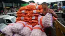 Pekerja menurunkan karung berisi bawang putih di Pasar Induk Kramatjati, Jakarta Timur, Rabu (5/2/2020). Kelangkaan pasokan bawang putih di dalam negeri diduga imbas dari penghentian impor produk dari China terkait pencegahan penyebaran virus Corona. (merdeka.com/magang/ Muhammad Fayyadh)