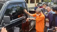 Tersangka AR tengah mempraktekan cara mencuri satu kendaraan pick up bermodalkan bambu tipis yang dibungkus lakban di depan wartawan di Mapolres Garut. (Liputan6.com/Jayadi Supriadin)