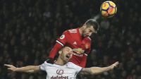 Pemain Manchester United, Henrikh Mkhitaryan (atas) berduel dengan pemain Burnley, Phil Bardsley (L) pada lanjutan Premier League di Old Trafford,  Manchester (26/12/2017).  MU bermain imbang 2-2. (AFP/Lindsey Parnaby)