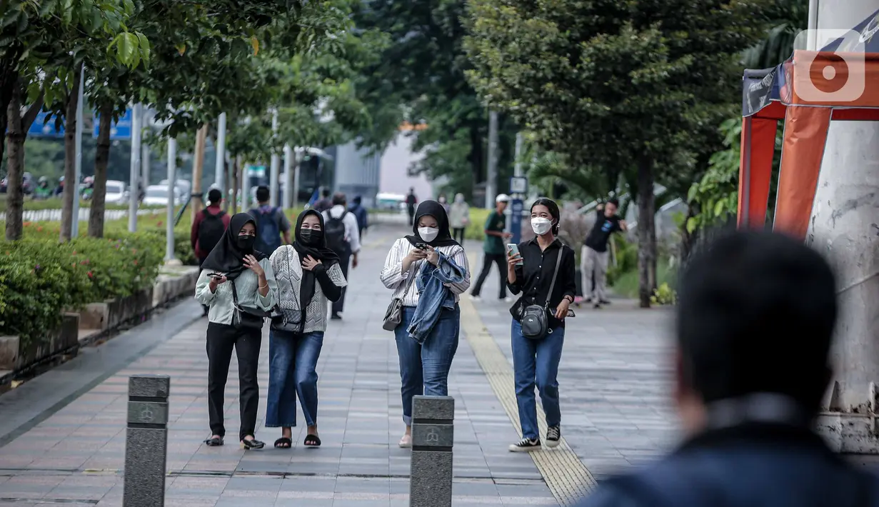 Sejumlah warga berjalan di Kawasan Sudirman, Jakarta, Kamis, (17/2/2022). Provinsi DKI Jakarta disebut sudah melewati gelombang ketiga Covid-19 yang dipicu oleh penyebaran virus corona varian Omicron. (Liputan6.com/Faizal Fanani)