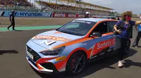 Sejumlah pengunjung berpose di depan Hyundai i30 N yang jadi safety car WSBK 2022 di Sirkuit Mandalika, Lombok, NTB, Minggu (13/11/2022). (Marco Tampubolon/Liputan6.com)