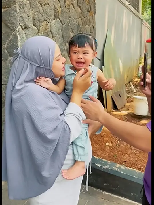 Baby Ameena tak mau ditinggal sus. Bocah yang tidak lama lagi akan menjadi kakak itu nengis kejer saat Suster yang merawatnya naik ke mobil.  [Youtube/attahalilintar]