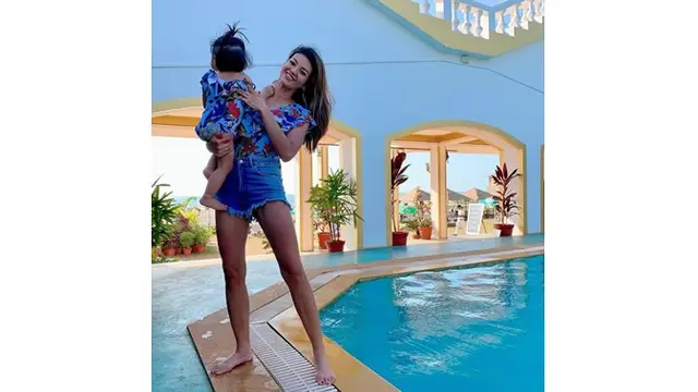 Farah dan putri kecilnya kompak mengenakan busana kembar. Pesonanya pun semakin terpancar.