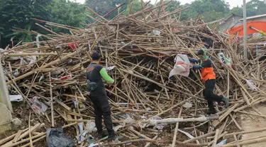 Petugas sedang memilah tumpukan bambu bekas sisa alat peraga kampanye di tempat penyaringan sampah di TB Simatupang, Jakarta, Jumat (16/2/2024). (Liputan6.com/Herman Zakharia)