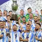 Pemain Argentina, Lionel Messi mengangkat trofi saat merayakan juara pada laga final Copa America 2024 di Hard Rock Stadium, Miami, Florida, Senin (15/07/2024) WIB. (AFP/Charly Triballeau)