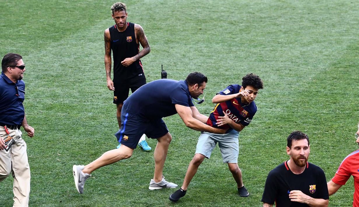 Seorang  fans mengejar penyerang Barcelona, Lionel Messi saat sesi latihan di Red Bull Arena di Harrison, New Jersey, (21/7). Barcelona akan berhadapan dengan Juventus pada ICC 2017. (AFP Photo/Jewel Samad) 