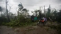 Pengendara melintas di dekat pohon yang tumbang setelah Badai Matthew menghantam wilayah Les Cayes di Haiti (4/10). Badai Matthew ini telah mengakibatkan banjir, banyak pohon tumbang dan ratusan rumah warga rusak parah. (REUTERS/Andres Martinez Casares)