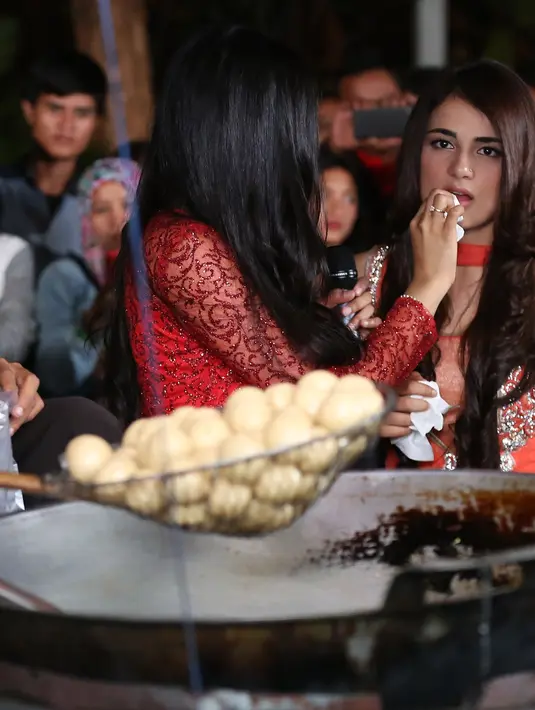  Terlihat dari ekspresi wajahnya, Radhika tampak menikmati setiap gigitan pada tahu bulat yang dimakannya itu. Tidak hanya mencicipi, namun Radhika juga melihat proses pembuatannya. (Bambang E. Ros/Bintang.com)