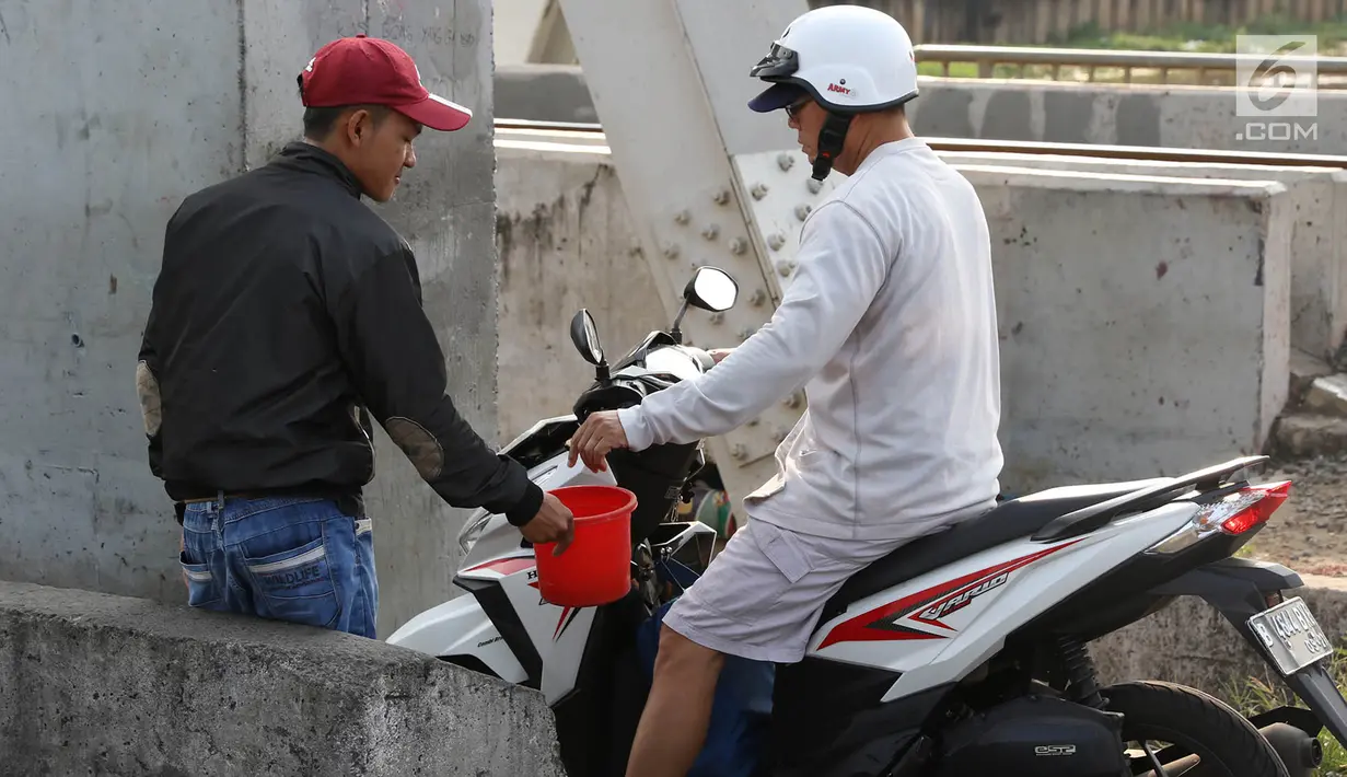 Pengendara sepeda motor melintasi jalan setapak di pinggir rel kereta di kawasan Tambora, Jakarta, Senin (10/7). Tidak tersedianya akses jalan untuk putar balik membuat warga terpaksa memanfaatkan jalan setapak tersebut. (Liputan6.com/Immanuel Antonius)