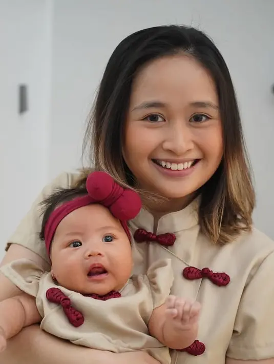 Gritte Agatha tampil mengenakan cheongsam warna coklat serasi dengan putrinya. Cheongsam tersebut memiliki kancing shanghai merah dan kerah tinggi. [@gritteagathaa]