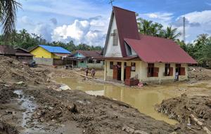 Warga desa berjalan menuju Gereja Protestan Angkola di desa Aek Ngadol, Tapanuli Selatan, Sumatera Utara, pada Kamis 25 Desember 2025, setelah banjir dan tanah longsor yang melanda di daerah tersebut pada akhir November 2025 lalu. Warga desa Aek Ngadol, Tapanuli Selatan, Sumatera Utara, merayakan Natal 2025 dalam suasana penuh keprihatinan. (AMROE/AFP)